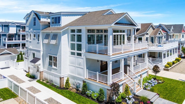 exterior space with a shingled roof, a residential view, metal roof, and a fenced backyard