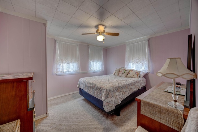 carpeted bedroom featuring crown molding and ceiling fan