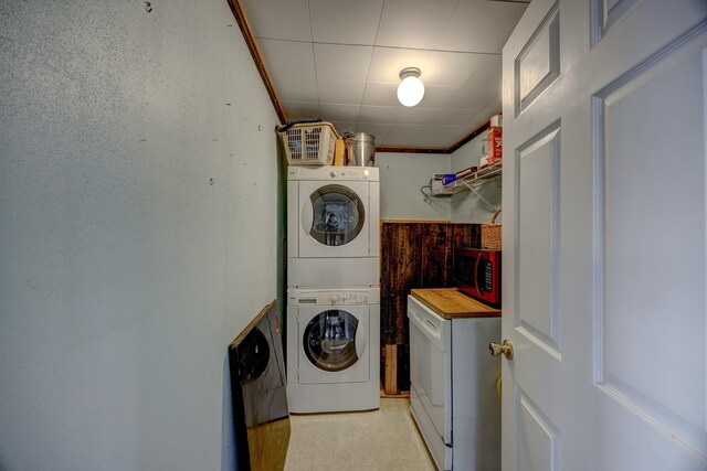 clothes washing area with stacked washer and clothes dryer