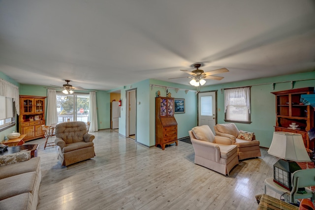 living room with light hardwood / wood-style flooring and ceiling fan