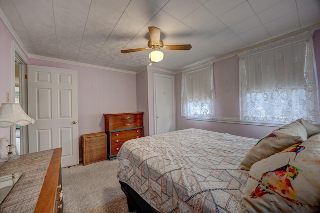 carpeted bedroom featuring ceiling fan and ornamental molding