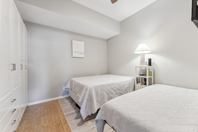 bedroom featuring ceiling fan, baseboards, and light wood-style floors