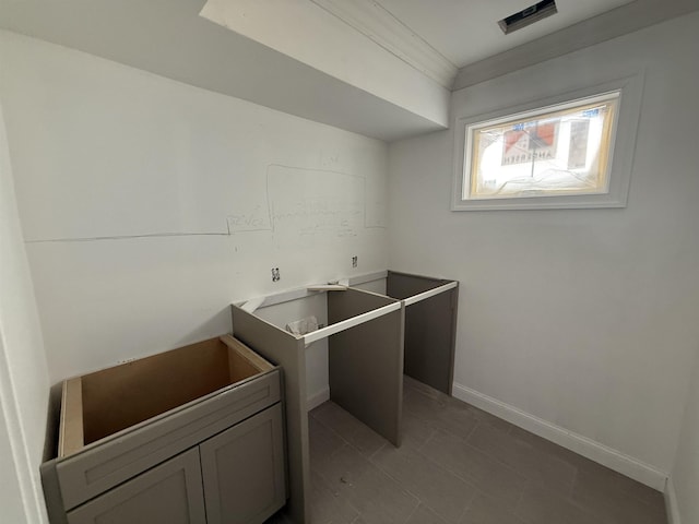 laundry room featuring light tile patterned floors and ornamental molding