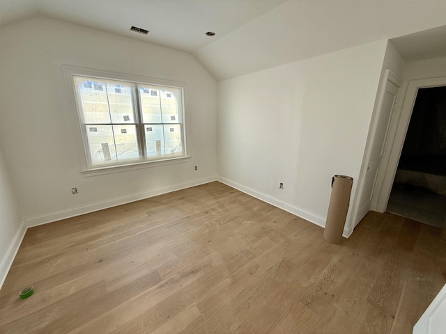 bonus room featuring lofted ceiling and light hardwood / wood-style floors