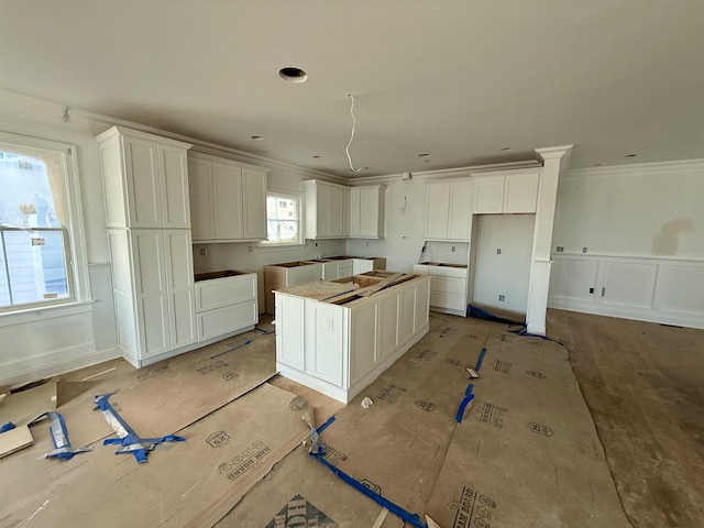 kitchen featuring white cabinetry, a kitchen island, and ornamental molding