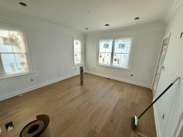 empty room with crown molding and light hardwood / wood-style flooring