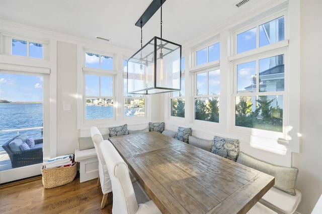 sunroom / solarium with breakfast area and a water view