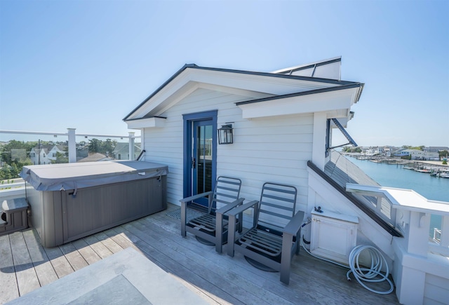 wooden deck featuring a water view and a hot tub