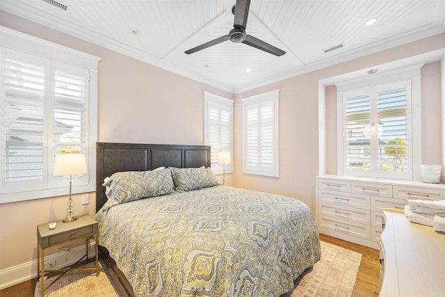 bedroom featuring multiple windows, ceiling fan, crown molding, and light wood-type flooring