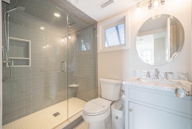 bathroom with vanity, toilet, and a shower with shower door