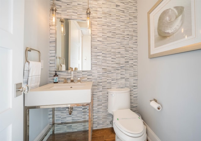 bathroom featuring toilet, sink, and tile walls