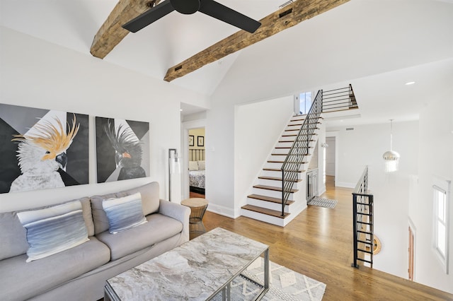 living room featuring ceiling fan, beamed ceiling, light hardwood / wood-style floors, and high vaulted ceiling