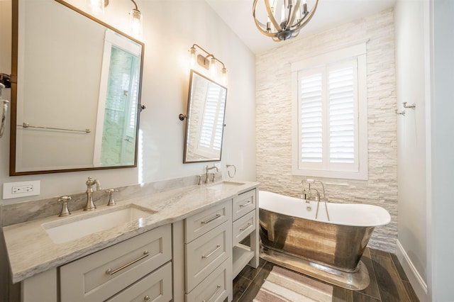 bathroom featuring a washtub, vanity, and an inviting chandelier