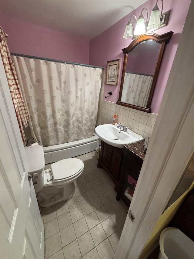 full bathroom featuring tile patterned floors, toilet, vanity, shower / bath combo, and tile walls