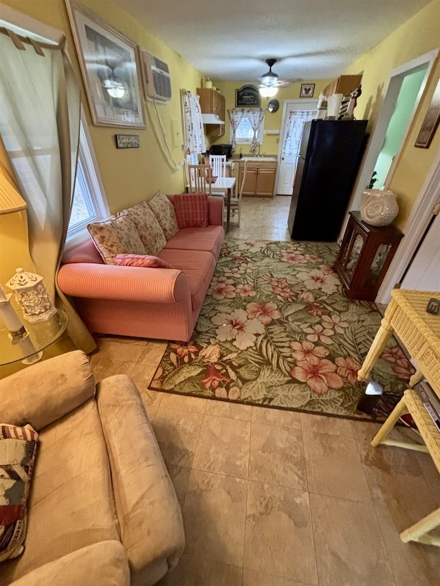 living room with a wall mounted AC and ceiling fan