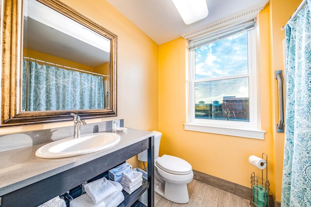 bathroom featuring vanity, wood finished floors, toilet, and baseboards