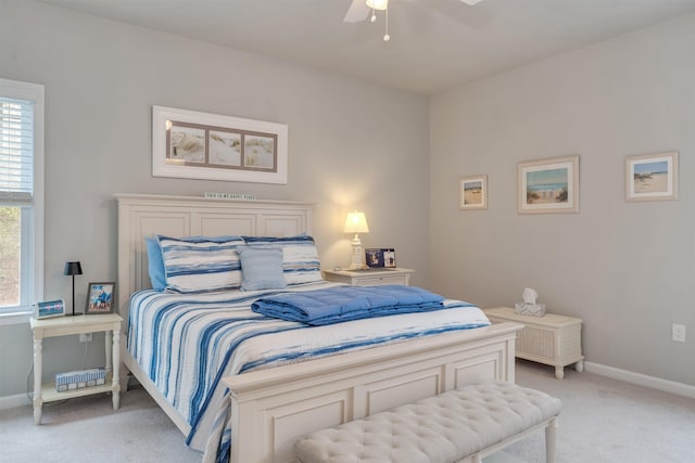 bedroom with light colored carpet, baseboards, and ceiling fan