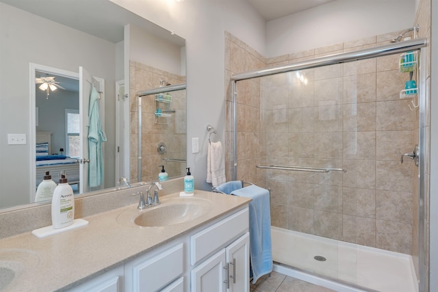 ensuite bathroom with a shower stall, double vanity, ensuite bath, a ceiling fan, and a sink