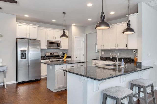 kitchen with visible vents, dark wood finished floors, appliances with stainless steel finishes, a peninsula, and white cabinets