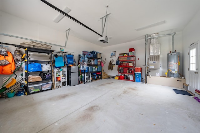 garage with heating unit, gas water heater, a garage door opener, and freestanding refrigerator