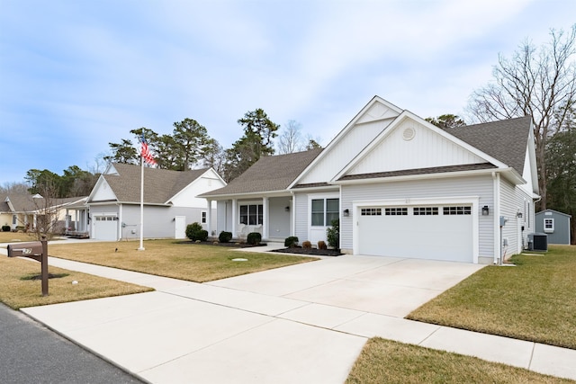 view of front of property featuring a garage, cooling unit, driveway, and a front lawn