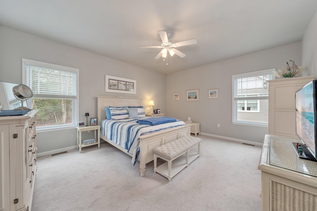 bedroom featuring light colored carpet, baseboards, and multiple windows