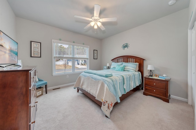 bedroom featuring ceiling fan, visible vents, baseboards, and light carpet