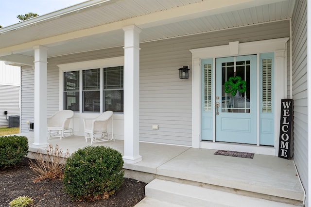 entrance to property featuring a porch and central AC