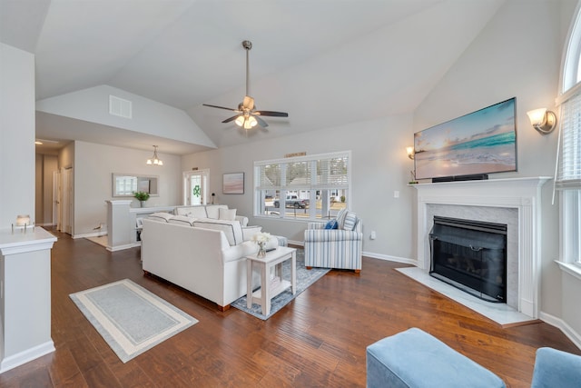 living room featuring vaulted ceiling, visible vents, a fireplace with flush hearth, and wood finished floors