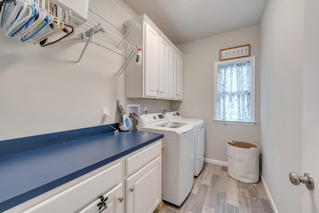 washroom with cabinet space, baseboards, light wood-style floors, and separate washer and dryer