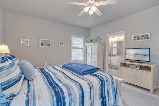 bedroom featuring light carpet, connected bathroom, and a ceiling fan