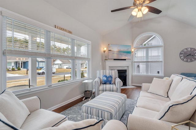 living room with a high end fireplace, plenty of natural light, lofted ceiling, and wood finished floors