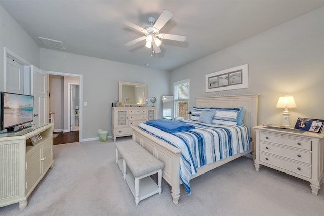 bedroom with visible vents, baseboards, light colored carpet, and ceiling fan