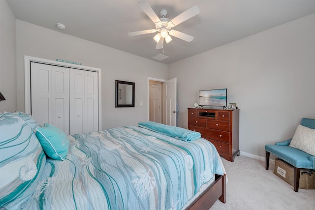 bedroom featuring a closet, light colored carpet, baseboards, and ceiling fan