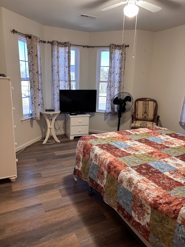 bedroom featuring ceiling fan, dark wood-style flooring, visible vents, and baseboards