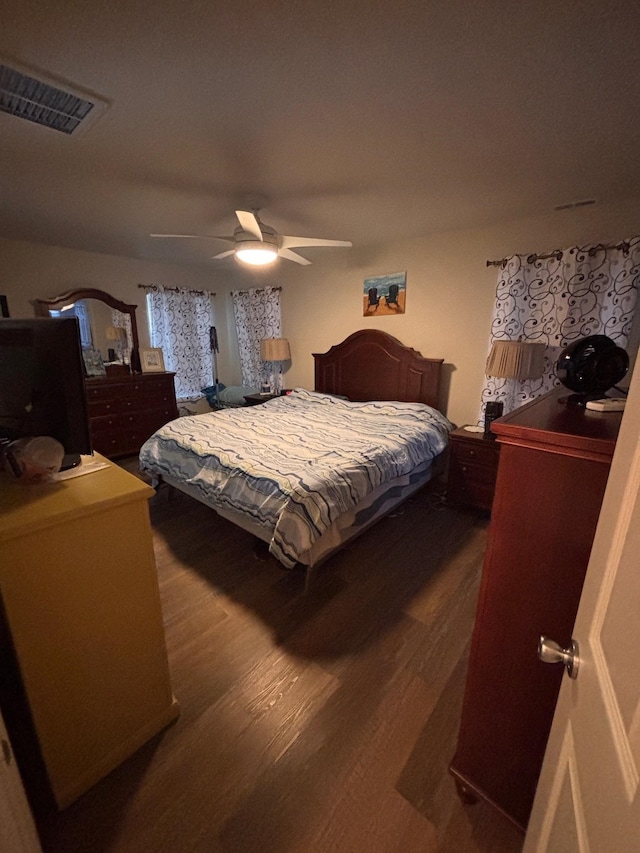 bedroom featuring visible vents, dark wood finished floors, and a ceiling fan