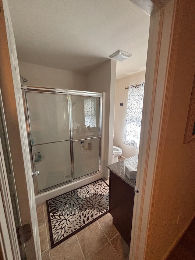 full bath featuring toilet, a stall shower, tile patterned floors, and vanity