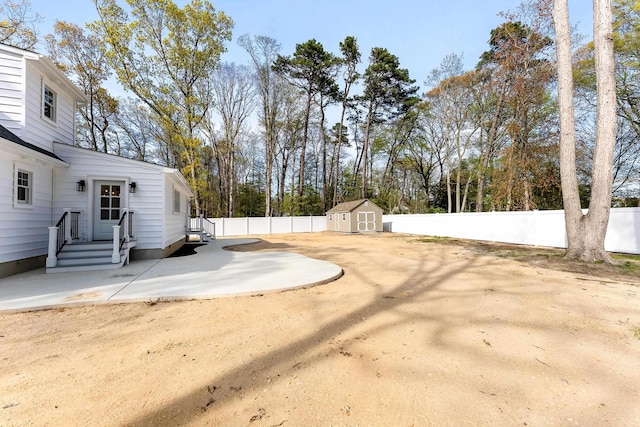 view of yard featuring an outdoor structure, a patio, a storage unit, and a fenced backyard