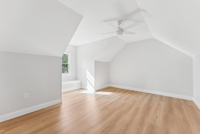 additional living space with baseboards, light wood-type flooring, a ceiling fan, and lofted ceiling