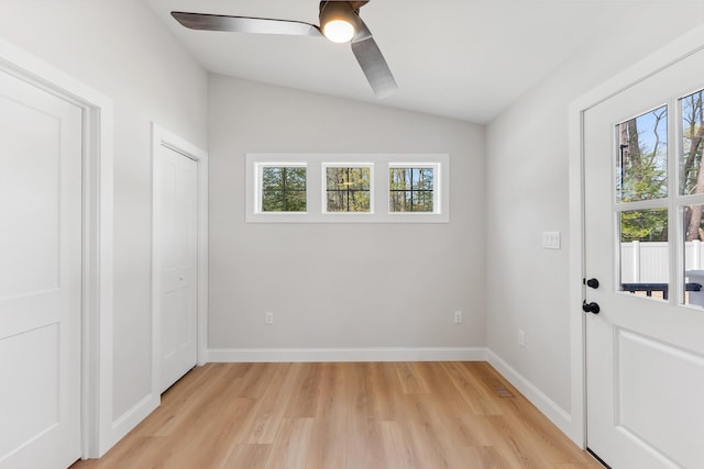 entryway featuring ceiling fan, baseboards, vaulted ceiling, and light wood-style floors