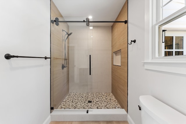 full bath with baseboards, a shower stall, and toilet