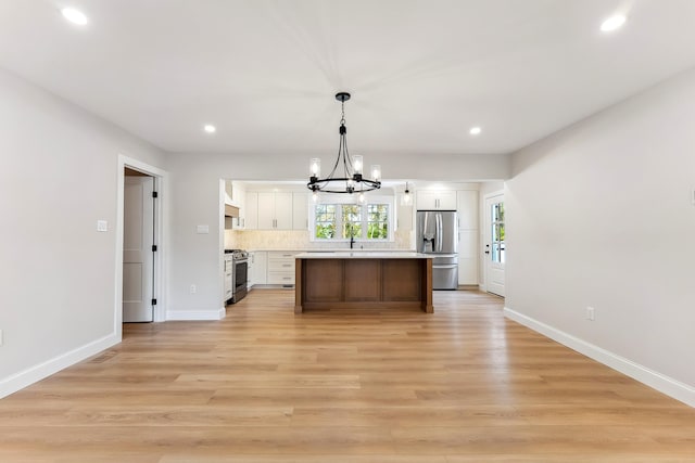 kitchen with appliances with stainless steel finishes, a chandelier, recessed lighting, and white cabinetry