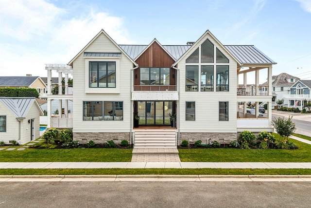 144 89th St, Stone Harbor, NJ 08247 - contemporary house featuring a standing seam roof, a front lawn, a metal roof, and a balcony