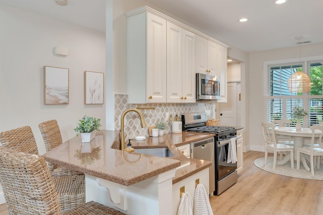 202 Osprey Dr Unit 202, Cape May Court House, NJ 08210 - kitchen with appliances with stainless steel finishes, light stone countertops, light wood-style flooring, recessed lighting, and a peninsula