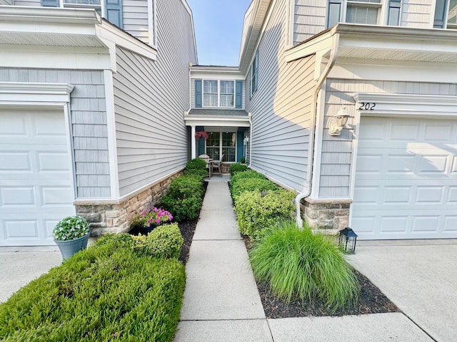 202 Osprey Dr Unit 202, Cape May Court House, NJ 08210 - view of exterior entry featuring stone siding, a garage, and driveway