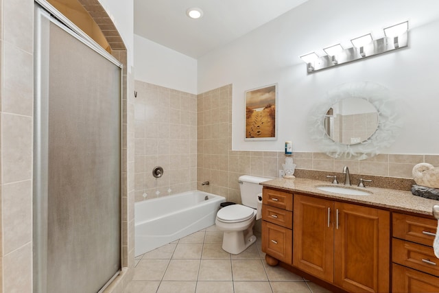 full bathroom with tile patterned flooring, shower with separate bathtub, toilet, vanity, and tile walls