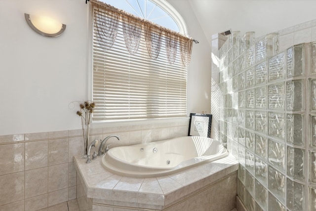 bathroom with a relaxing tiled tub and lofted ceiling