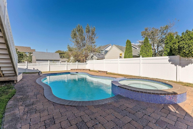 view of swimming pool featuring an in ground hot tub