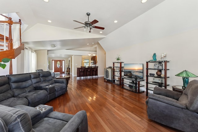 living room featuring wood-type flooring, ceiling fan with notable chandelier, and lofted ceiling