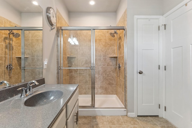 bathroom featuring vanity, a shower with shower door, and tile patterned floors